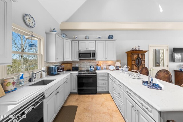 kitchen with high vaulted ceiling, backsplash, black appliances, kitchen peninsula, and sink