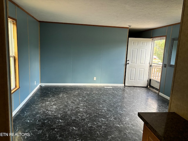 spare room featuring ornamental molding and a textured ceiling