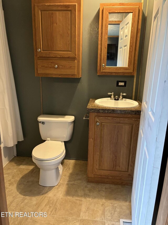 bathroom featuring vanity, toilet, and tile patterned floors