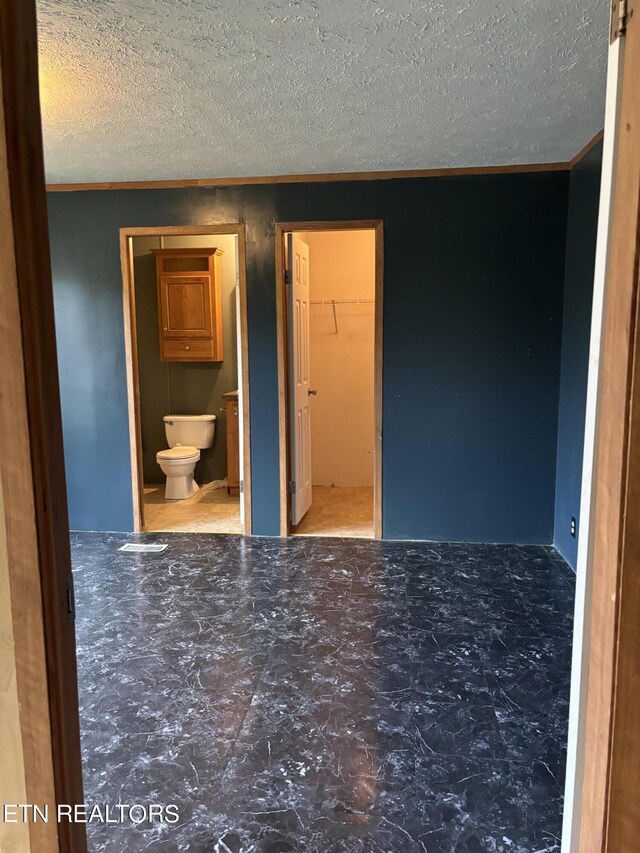 unfurnished room featuring crown molding and a textured ceiling