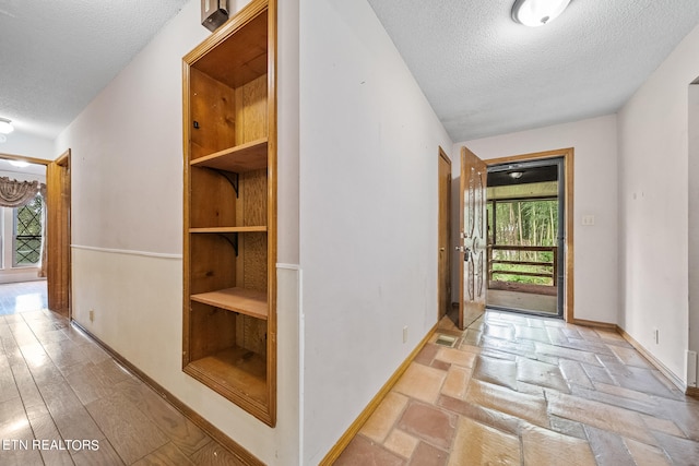 entryway with light hardwood / wood-style flooring and a textured ceiling