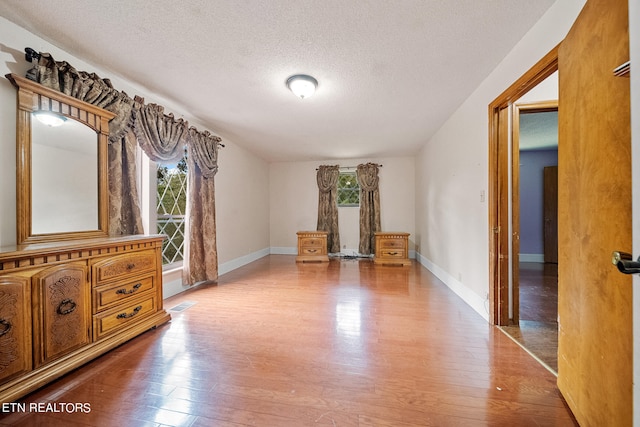 unfurnished bedroom featuring a textured ceiling and hardwood / wood-style floors