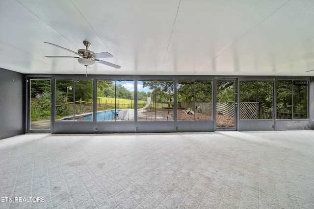 unfurnished sunroom featuring ceiling fan