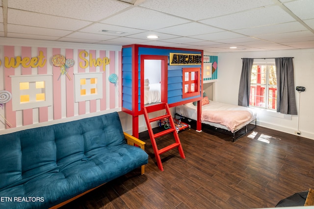 bedroom featuring a drop ceiling and hardwood / wood-style floors