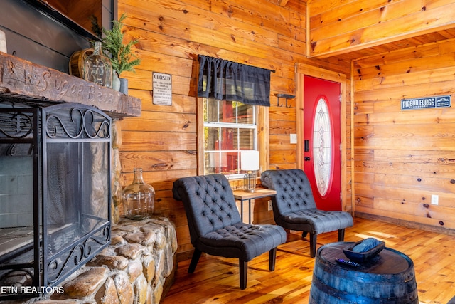 sitting room featuring wooden walls and hardwood / wood-style floors