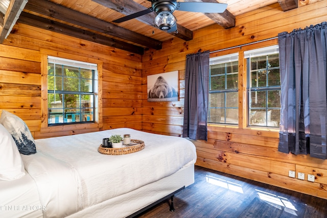 bedroom featuring wood-type flooring, wood walls, beam ceiling, and ceiling fan