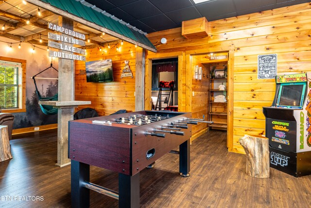 recreation room with wooden walls and dark hardwood / wood-style floors