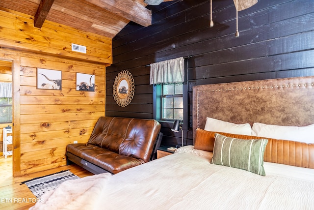 bedroom with vaulted ceiling with beams, hardwood / wood-style flooring, wood walls, and multiple windows