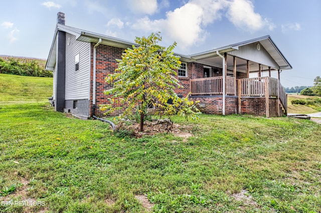 rear view of property with a yard and a deck