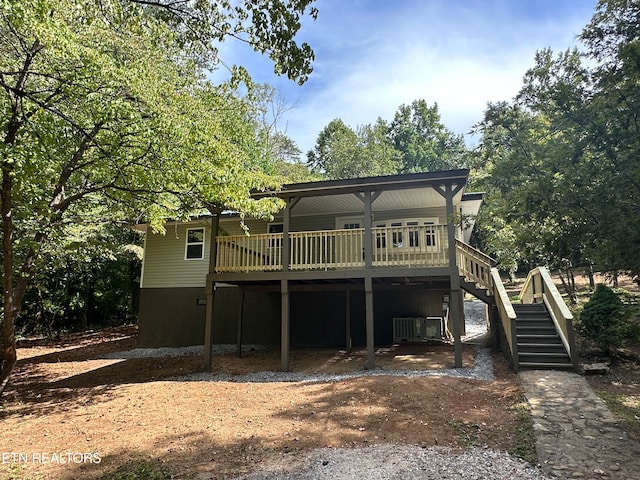 rear view of property with cooling unit and a wooden deck