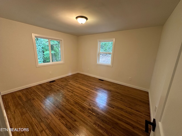 spare room featuring dark hardwood / wood-style flooring