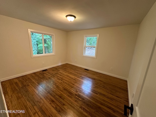 unfurnished room with dark hardwood / wood-style flooring