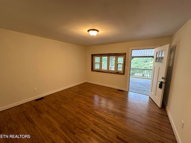 unfurnished room featuring dark wood-type flooring