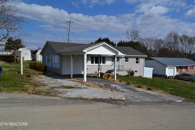 view of front of house featuring a front yard, brick siding, driveway, and metal roof