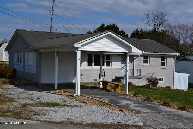 bungalow-style house featuring metal roof and brick siding