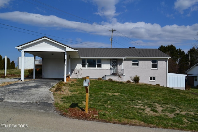 ranch-style house with aphalt driveway, an attached carport, a front yard, metal roof, and brick siding