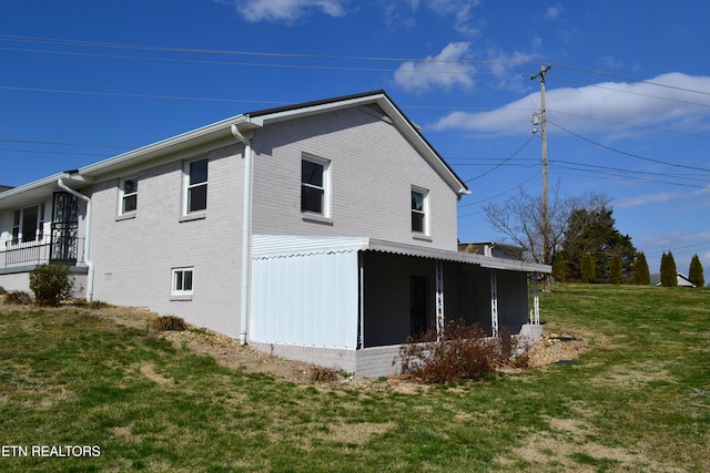 view of side of home with a yard and brick siding