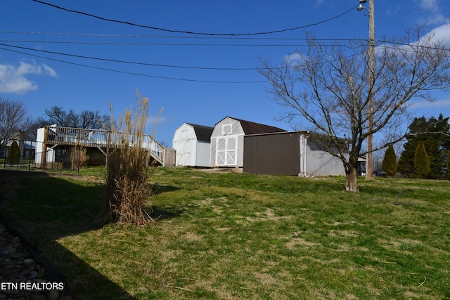 view of yard with a deck, a shed, and an outdoor structure