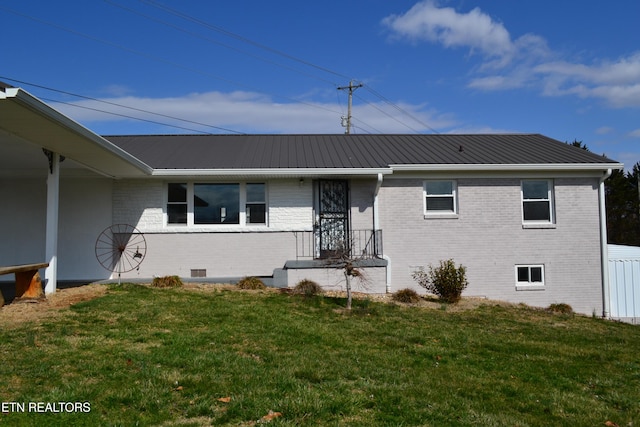 view of front of house with crawl space, metal roof, brick siding, and a front yard