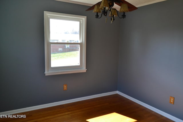 spare room with dark wood-type flooring and baseboards