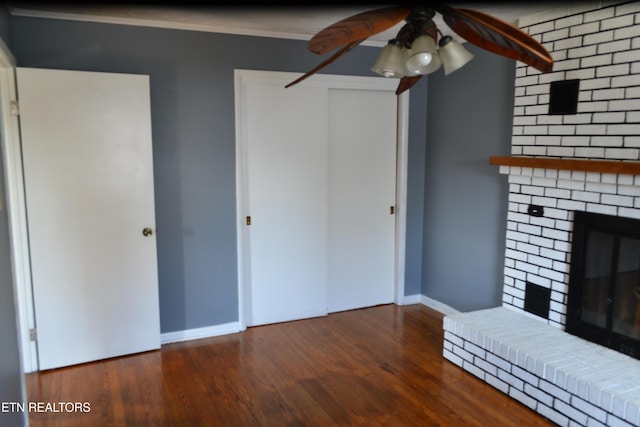 unfurnished living room with a fireplace, a ceiling fan, baseboards, and wood finished floors