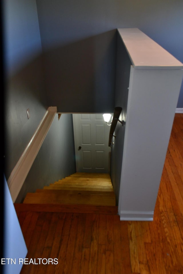 stairs with baseboards and wood finished floors