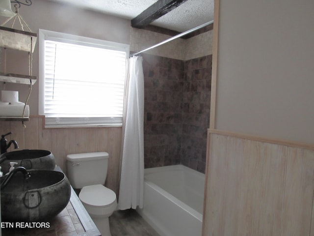 full bath featuring shower / bathtub combination with curtain, toilet, and a textured ceiling