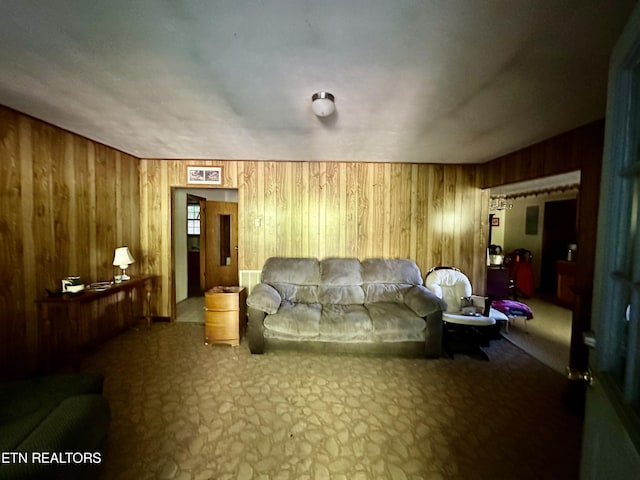carpeted living room with wooden walls and visible vents