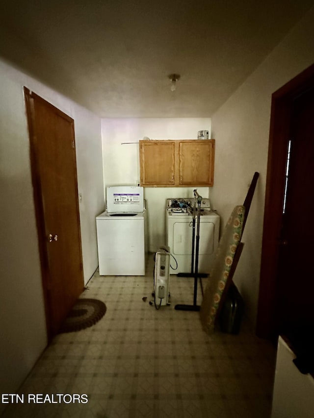 washroom featuring washing machine and clothes dryer, cabinet space, and light floors