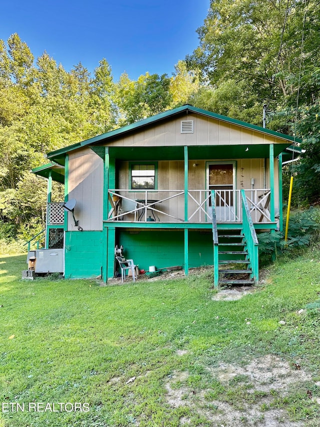 back of property featuring a lawn and a porch