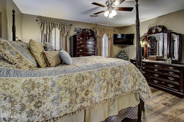 bedroom with hardwood / wood-style flooring, ceiling fan, and multiple windows