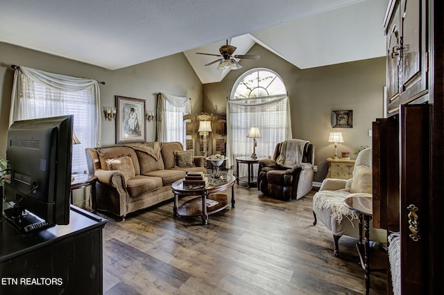 living room featuring lofted ceiling, dark wood-type flooring, and ceiling fan