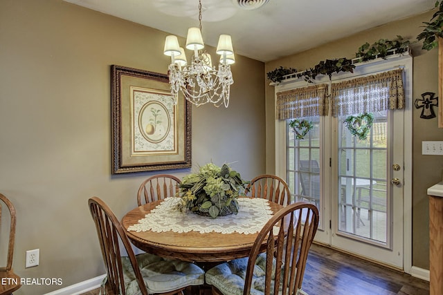 dining space with a notable chandelier, baseboards, and wood finished floors