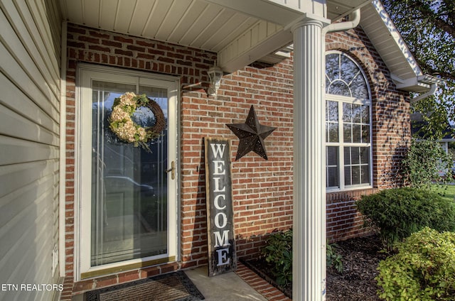 entrance to property featuring brick siding