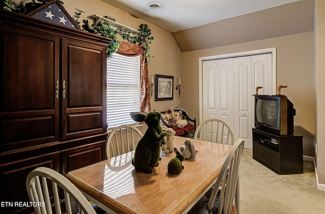 dining space with light colored carpet and lofted ceiling