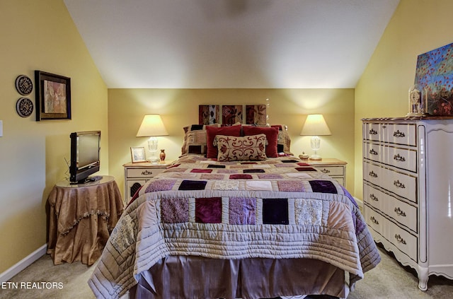 bedroom featuring lofted ceiling and light carpet