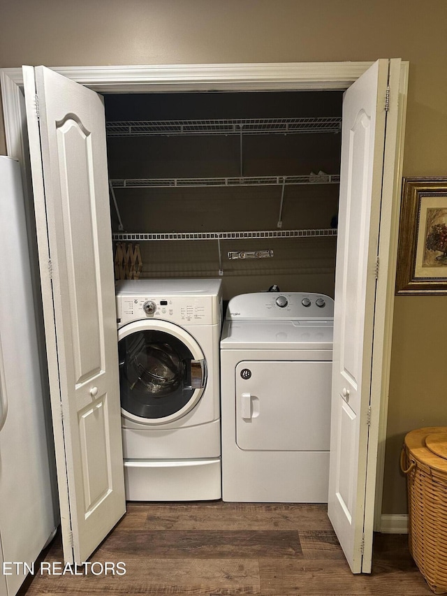 clothes washing area with dark wood-type flooring and washer and clothes dryer