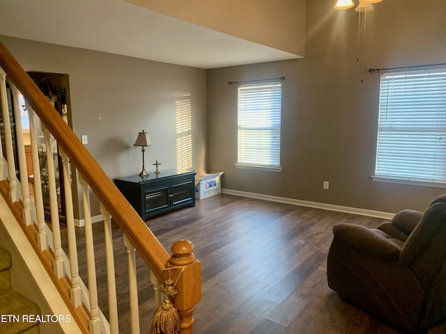 living area featuring stairs, wood finished floors, and baseboards