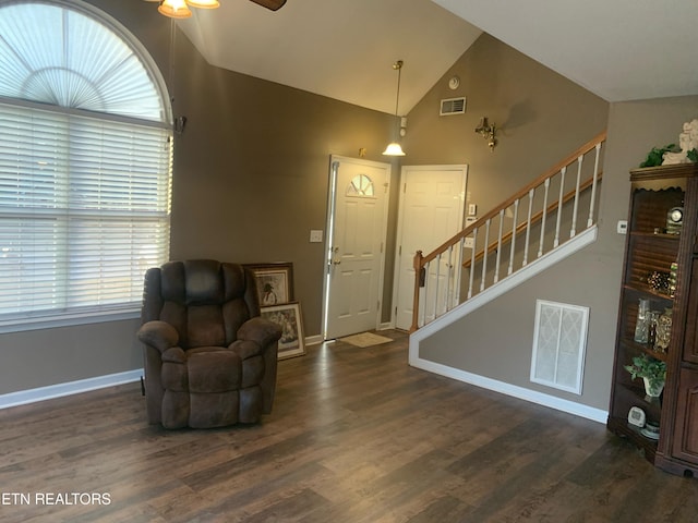 foyer featuring visible vents, wood finished floors, and stairway