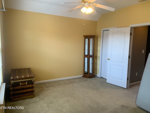 unfurnished bedroom featuring lofted ceiling, carpet flooring, baseboards, and a closet