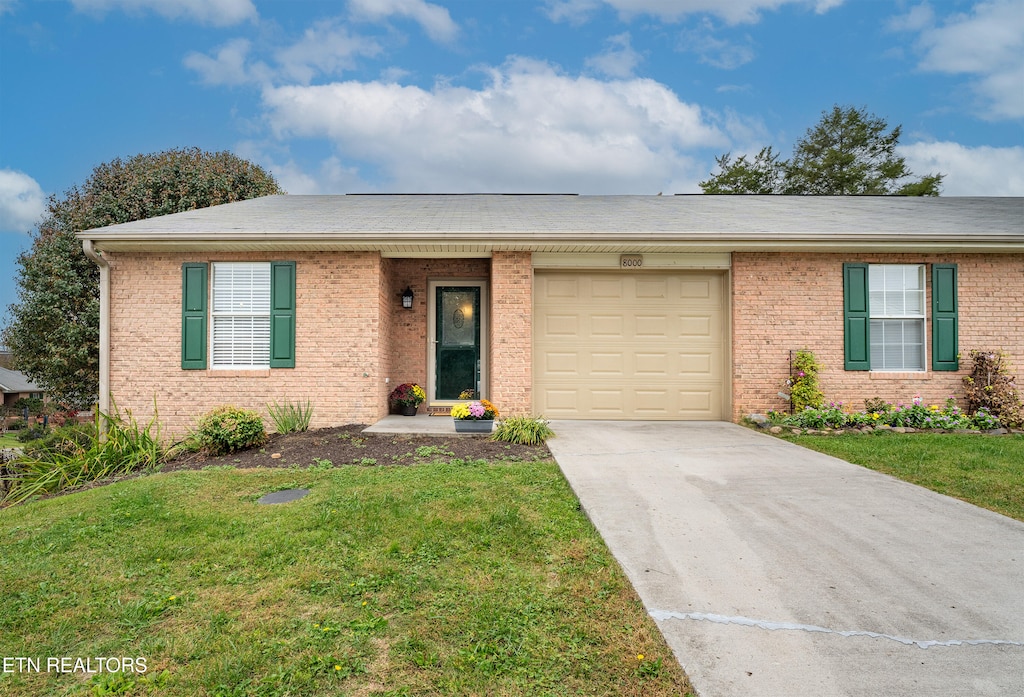 ranch-style house with a front yard and a garage