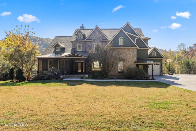 view of front of property featuring a porch, a front lawn, and a garage