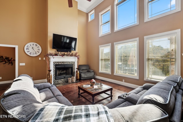 living room with crown molding, wood-type flooring, a healthy amount of sunlight, and a high ceiling