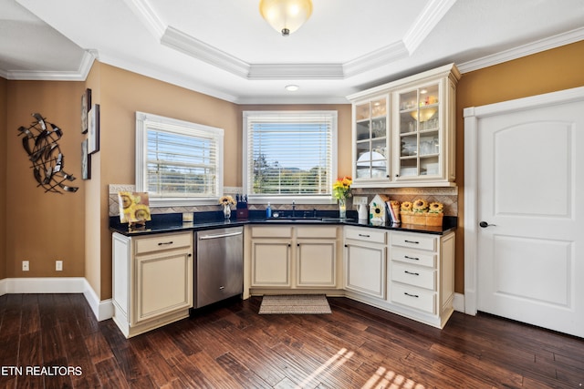 kitchen featuring crown molding, stainless steel dishwasher, dark wood-type flooring, and cream cabinetry