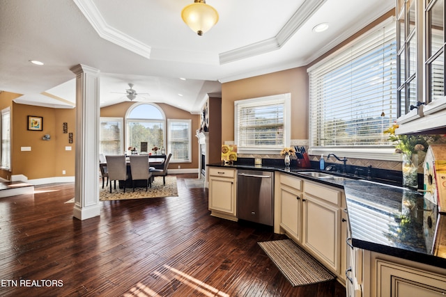 kitchen featuring cream cabinetry, stainless steel dishwasher, dark wood-type flooring, and a wealth of natural light