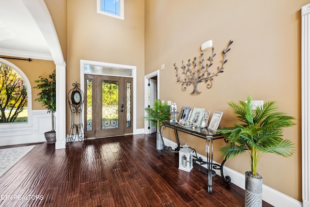 entrance foyer featuring crown molding, hardwood / wood-style flooring, and a high ceiling