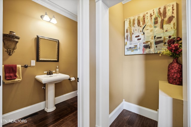 bathroom featuring ornamental molding and hardwood / wood-style flooring