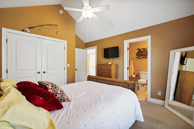 carpeted bedroom with lofted ceiling, a closet, ensuite bathroom, and ceiling fan