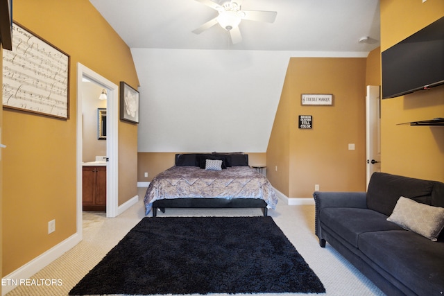 bedroom featuring connected bathroom, light colored carpet, lofted ceiling, and ceiling fan