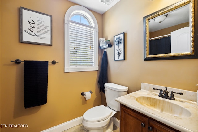 bathroom featuring vanity, toilet, and tile patterned flooring